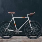 gray fixie bike leaning on black wall